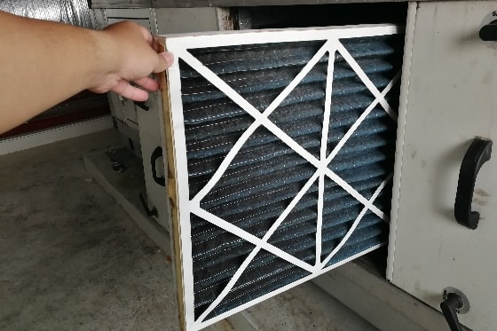 A photo of a dirty air filter being removed from a furnace