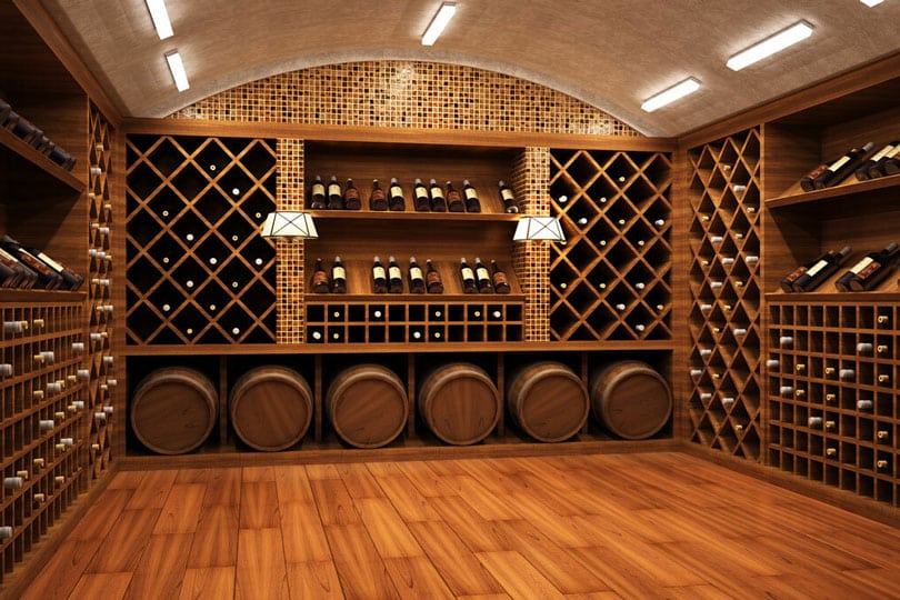 A wine room with wood floors and custom wood shelving for bottles and casks