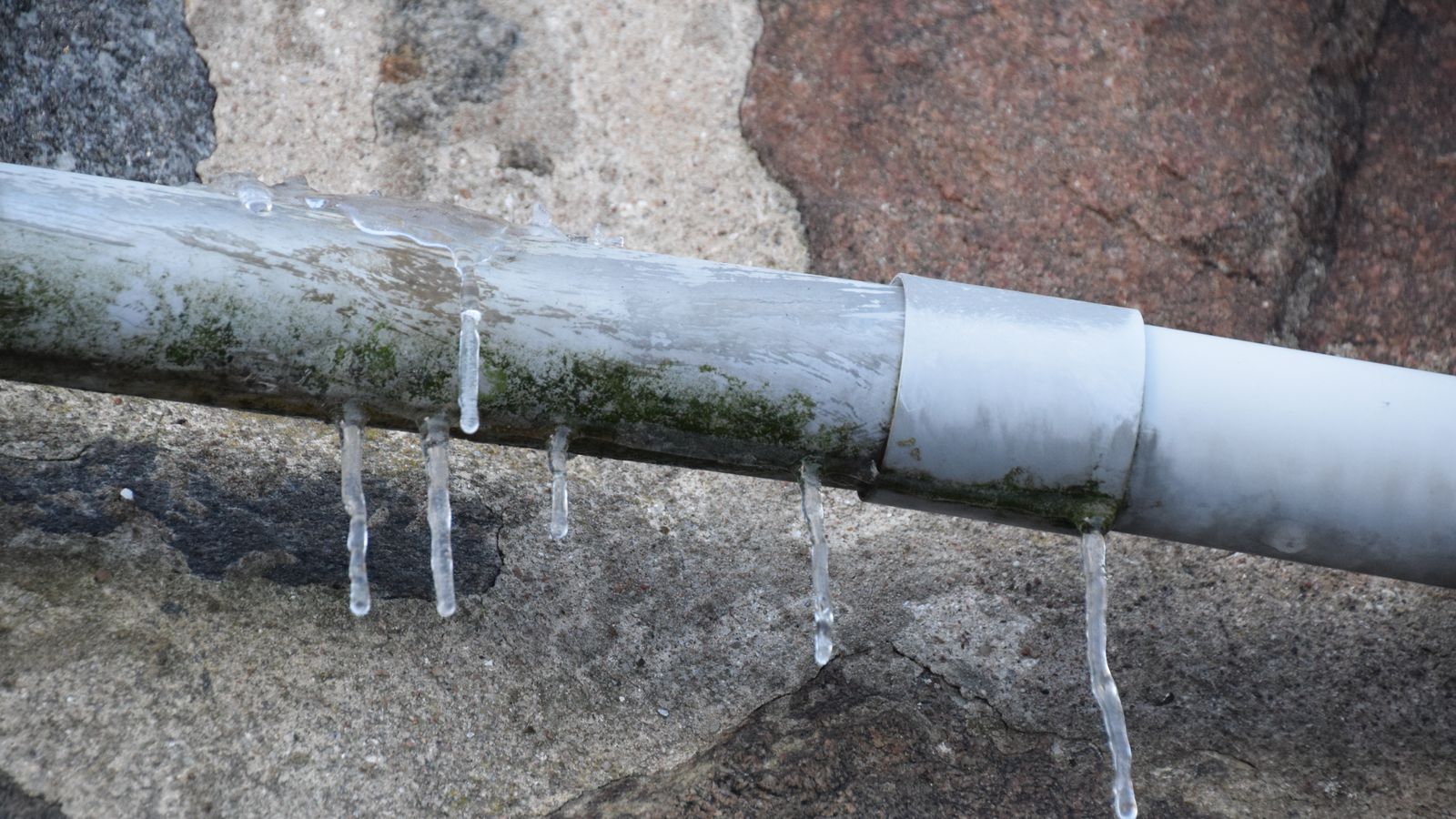 A pipe frozen over with icicles dripping