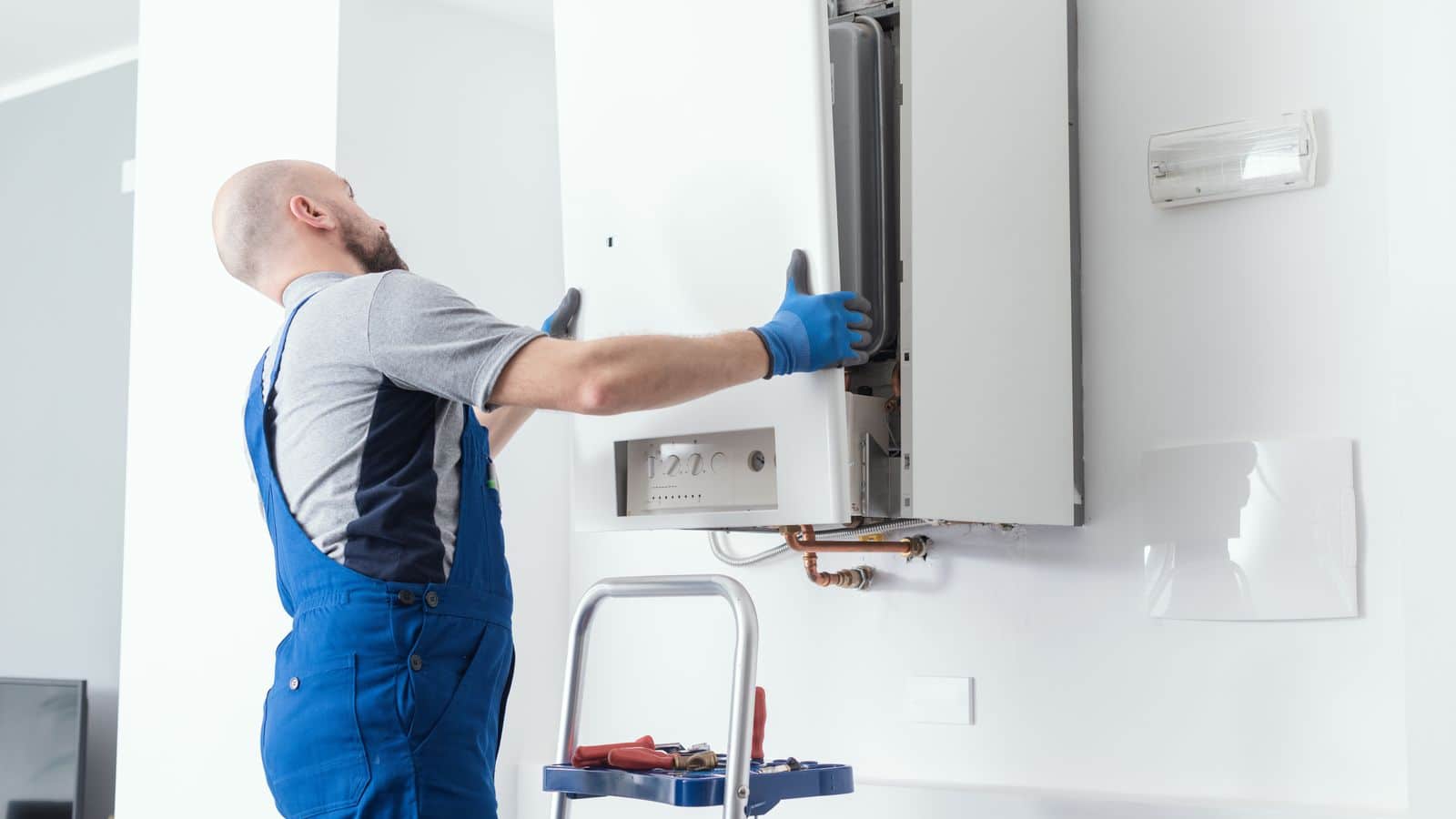 Plumber removing the front panel of a tankless water heater